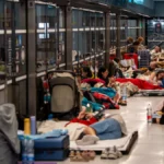 Israeli civilians sprinting into a subway bomb shelter as air raid sirens sound