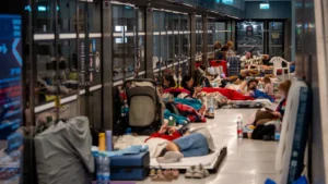 Israeli civilians sprinting into a subway bomb shelter as air raid sirens sound