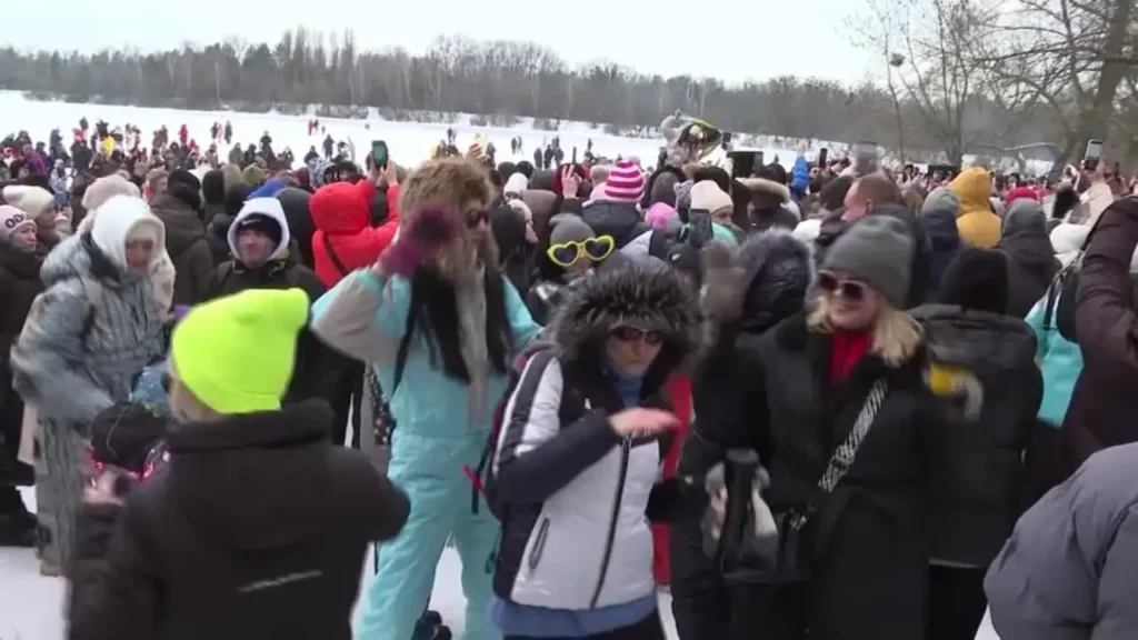 hundreds of people dancing on a frozen river